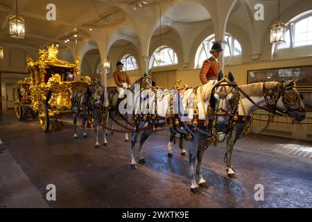 Il Gold State Coach usato dalla famiglia reale britannica immagazzinato nei Royal Mews Foto Stock