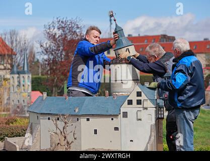 2 aprile 2024, Sassonia-Anhalt, Wernigerode: I dipendenti del parco in miniatura di Kleiner Harz allestirono un modello del castello di Falkenstein. In preparazione della nuova stagione, la costruzione di oltre 60 edifici in miniatura è continuata. Quando la stagione inizierà il 06.04.2024, il parco sarà stato ripiantato, tra le altre cose. Foto: Matthias Bein/dpa/ZB Foto Stock