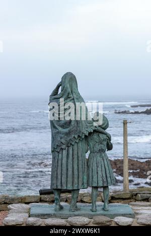 Statua commemorativa di una donna pescatrice e di sua figlia che guarda verso il mare, creata in memoria di coloro che si sono persi in mare, Cairnbulg, Aberdeenshire, Scozia. Foto Stock