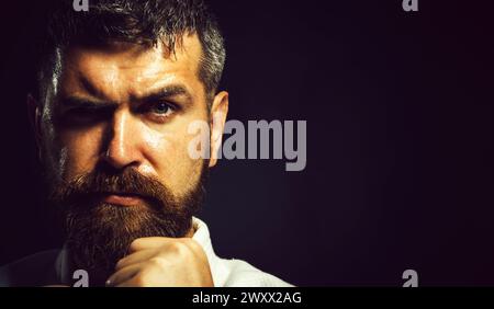 Primo piano ritratto dell'uomo di karate in kimono su allenamento di lotta in palestra. Maestro di arti marziali in posizione di combattimento su sfondo nero. Combattente di karate Foto Stock