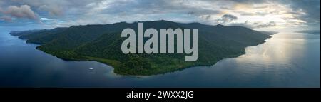 La fitta foresta pluviale copre la costa panoramica di Batanta meridionale, Raja Ampat. Questa regione biodiversificata è conosciuta come il cuore del Triangolo dei Coralli. Foto Stock