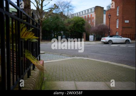 strada vuota durante il giorno a londra con ringhiera in metallo nero con appartamenti fuori fuoco sullo sfondo Foto Stock