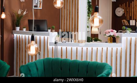 La lussuosa e vuota reception dell'hotel è pronta ad accogliere gli ospiti all'ingresso, la reception è utilizzata per il processo di check-in e per le registrazioni durante i viaggi di vacanza. Elegante lobby con pavimenti in marmo, concetto turistico. Foto Stock