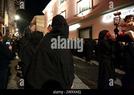 30 marzo 2024, Sessa Aurunca, Campania/Caserta, Italia: Marzo 29, 2024, Sessa Aurunca, Caserta, Italia: l'Arciconfraternita dei SS.Crocifisso e Monte dei morti con tutti i suoi confratelli ha partecipato al venerdì Santo alla processione dei Misteri della passione e della morte di Gesù per le vie del centro storico. La processione al tramonto è iniziata dalla Chiesa di San Giovanni a Villa. Momenti di preghiera e canti hanno accompagnato le statue del Cristo morto e delle donne in lutto per tutta la serata. Lungo la strada, furono accesi grandi fuochi di branchi di rami. Alcune donne in lutto Foto Stock