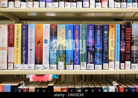 Libreria con grandi titoli di libri stampati di romanticismo americano, fantasy, suspense autrice Nora Roberts; romanzi romantici, libri, fiction popolare. Foto Stock