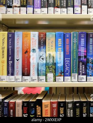 Libreria con grandi titoli di libri stampati di romanticismo americano, fantasy, suspense autrice Nora Roberts; romanzi romantici, libri, fiction popolare. Foto Stock