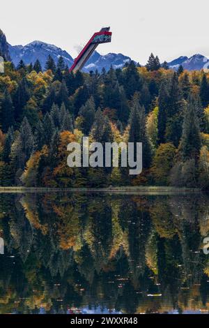 Lago Freibergsee in autunno, alle sue spalle il salto con gli sci Heni-Klopfer, le Alpi Allgaeu, Allgaeu, Baviera, Germania Foto Stock