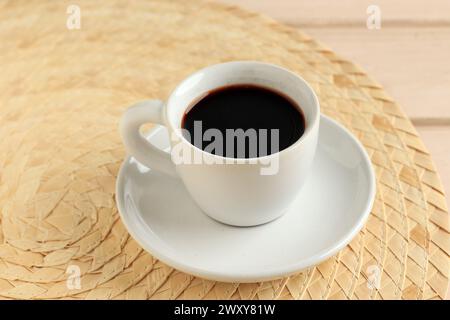 Una tazza di caffè nero su un tavolo di legno Foto Stock