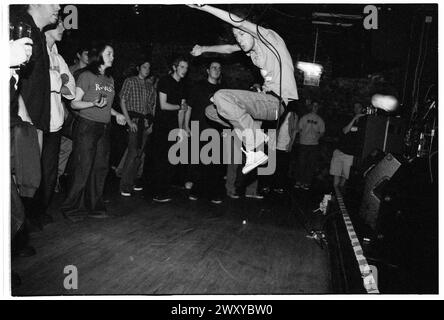 HUNDRED REASONS, EMO CONCERT, 2001: Colin Doran della band Emo rock Hundred Reaons salta in mezzo alla folla suonando al Clwb Ifor Bach Welsh Club in Galles, Regno Unito, 14 maggio 2001. Foto: Rob Watkins. INFO: 100 Reasons, un gruppo rock post-hardcore britannico formatosi nel 1999 a Londra, ha guadagnato il plauso per le loro energiche esibizioni dal vivo e la scrittura emotiva delle canzoni. Successi come "If i Could" e "Silver" hanno mostrato il loro suono dinamico, guadagnando loro un seguito devoto nella scena musicale dei primi anni '2000. Foto Stock