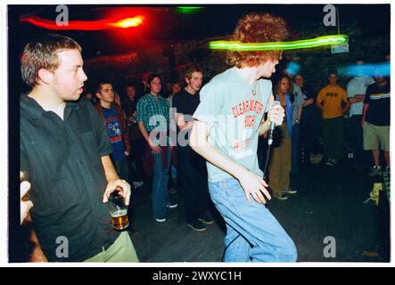 HUNDRED REASONS, EMO CONCERT, 2001: Colin Doran della band Emo rock Hundred Reaons salta in mezzo alla folla suonando al Clwb Ifor Bach Welsh Club in Galles, Regno Unito, 14 maggio 2001. Foto: Rob Watkins. INFO: 100 Reasons, un gruppo rock post-hardcore britannico formatosi nel 1999 a Londra, ha guadagnato il plauso per le loro energiche esibizioni dal vivo e la scrittura emotiva delle canzoni. Successi come "If i Could" e "Silver" hanno mostrato il loro suono dinamico, guadagnando loro un seguito devoto nella scena musicale dei primi anni '2000. Foto Stock