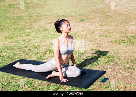 donna che fa esercizi di stretching usando il telefono Foto Stock