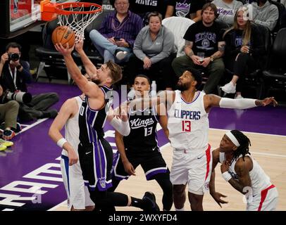 Sacramento, Stati Uniti. 2 aprile 2024. Domantas Sabonis (L, davanti) dei Sacramento Kings va a letto durante la partita di stagione regolare NBA 2023-2024 tra Sacramento Kings e Los Angeles Clippers a Sacramento, Stati Uniti, 2 aprile 2024. Crediti: Li Jianguo/Xinhua/Alamy Live News Foto Stock