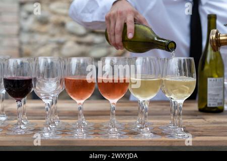 Il cameriere riempie i bicchieri di vino bianco, rosa e rosso alla reception Foto Stock