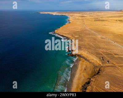 Ripresa aerea che mostra la costa mozzafiato di Fuerteventura, catturando il suo potenziale di surf con le acque blu che incontrano le coste dorate. Foto Stock