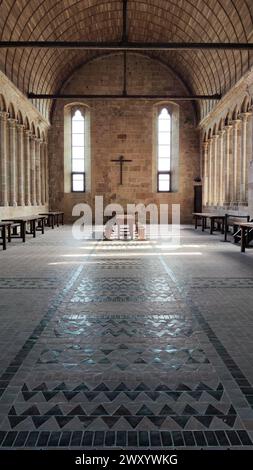 Sul lato della chiesa e del chiostro di Mont Saint Michel in Francia, c'è una grande sala con tavoli, forse era una vecchia sala da pranzo Foto Stock