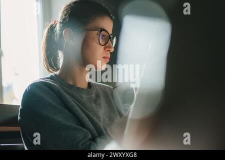 Una giovane pittrice adorabile pratica la pittura su tela con pitture che si divertono con il processo di hobby creativo in un accogliente laboratorio moderno. Istruzione, creazione Foto Stock
