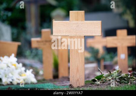 molte croci di legno su una tomba fresca in un cimitero per i poveri Foto Stock