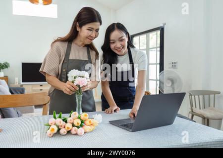 madre e figlia organizzano i fiori insieme come hobby. madre e figlia trascorrono del tempo libero a fare fiori organizzando attività insieme e guardando Foto Stock