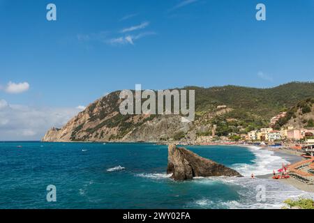 Vista sulla spiaggia di Monterosso al Mare con ombrelloni colorati e su una montagna Foto Stock