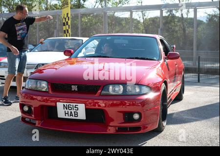 Vista frontale di una Nissan Skyline GT-R33 rossa di nona generazione in occasione di un incontro con un'auto sportiva giapponese. Foto Stock