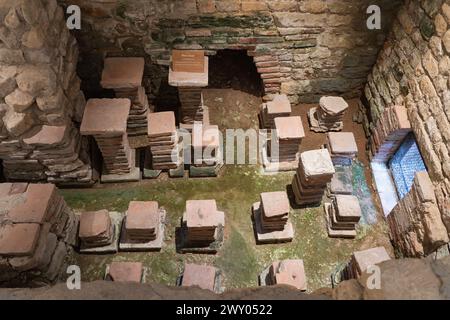 Camera calda (calidarium) con riscaldamento ipocausto sotto il pavimento e pilastri in mattoni (pilae) nel bagno occidentale (balneum) a Chedworth Roman Villa, Inghilterra Foto Stock