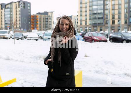 Una bella giovane donna con dreadlocks biondi cammina per la città in inverno Foto Stock