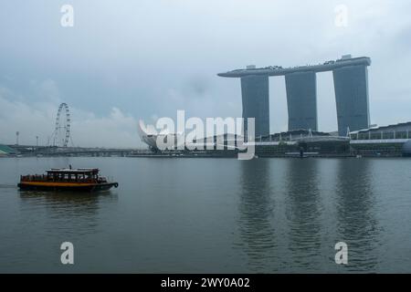 Marina Bay Sands Resort sullo skyline di Singapore con tradizionale bumboat in primo piano. Foto Stock