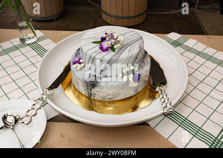 Torta nuziale con decorazioni in marmo e fiori. Foto Stock