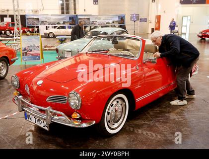 Essen, Germania. 3 aprile 2024. Un visitatore di settore guarda un Karmann Ghia alla mostra di auto d'epoca "Techno classica". Techno-classica è una delle più grandi fiere di auto d'epoca al mondo. Sono in mostra più di 2700 auto d'epoca a prezzi che vanno da meno di 10.000 a diversi milioni di euro. Crediti: Roland Weihrauch/dpa/Alamy Live News Foto Stock