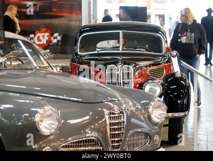 Essen, Germania. 3 aprile 2024. Le auto classiche di Alfa Romeo (l) e BMW sono esposte alla fiera delle auto classiche "Techno classica". Techno-classica è una delle più grandi fiere di auto d'epoca al mondo. Più di 2700 auto d'epoca sono esposte a prezzi che vanno da meno di 10.000 a diversi milioni di euro. Crediti: Roland Weihrauch/dpa/Alamy Live News Foto Stock