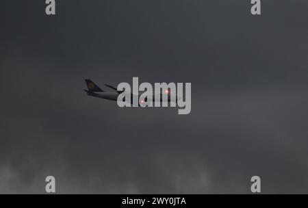 3 aprile 2024, Assia, Francoforte sul meno: Le luci di posizione di un Boeing 747 della Lufthansa lampeggiano mentre si avvicina all'aeroporto di Francoforte, mentre nuvole di pioggia scure si spostano sulla regione del Reno-meno. Foto: Arne Dedert/dpa Foto Stock