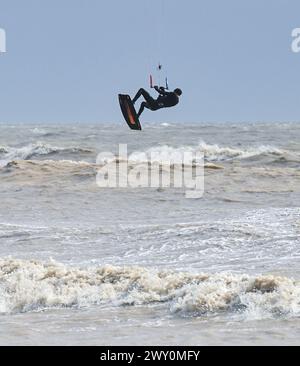 Worthing UK 3 aprile 2024 - i Kite surfisti sfruttano al massimo i forti venti a Lancing Near Worthing durante il vento lungo la costa meridionale oggi: Credit Simon Dack / Alamy Live News Foto Stock