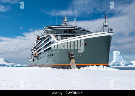 Hanusse Bay, Antartide - 14 gennaio 2024: Nave da crociera Seabourn Inseguimento sfondando il ghiaccio marino in Antartide. Foto Stock