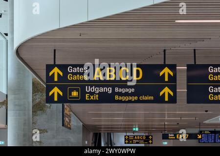 Cartello del terminal dell'aeroporto (gate a b c d esistente) con soffitto bianco in lingua inglese e danese a Copenaghen (moderna, direzionale) Foto Stock