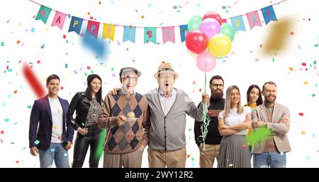 Anziani che festeggiano il compleanno con un gruppo di giovani con coriandoli e decorazioni isolate su sfondo bianco Foto Stock