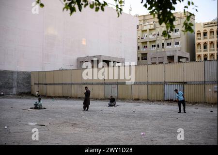 Männer stehen oder sitzen auf einem unbebauten Platz - Dubai - Emirato di Vereinigte Arabische, 09.01.2024 *** uomini in piedi o seduti in un lotto vacante Dubai Emirati Arabi Uniti, 09 01 2024 Foto Stock