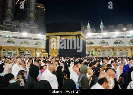 La Mecca, Arabia Saudita - 7 marzo 2023: Moltitudine di pellegrini che camminano per la Kaaba durante l'Hajj in Mecca - la città più sacra dell'Islam - foto serale con buio Foto Stock