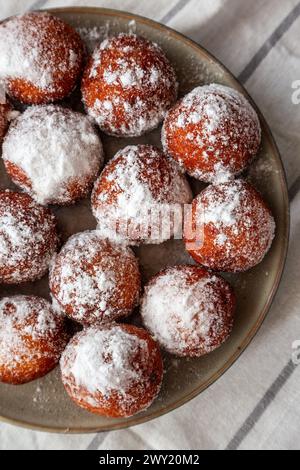 Ciambelle fritte fatte in casa con zucchero a velo su un piatto, vista dall'alto. Foto Stock