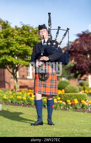 Uomo scozzese in clan tartan, che suona le cornamuse, uno strumento musicale tradizionale scozzese. Dumfries, Scozia. Foto Stock