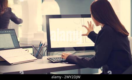 Architetto che progetta progetti per la ristrutturazione di abitazioni, utilizzando il moderno software cad su computer per creare una nuova planimetria per i clienti. L'ingegnere esegue misurazioni sugli schizzi di layout in ufficio. Foto Stock