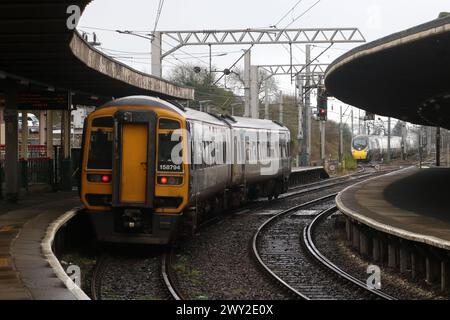 Treni Nord Express Sprinter dmu nella stazione di Carnforth e passando davanti all'Avanti West Coast pendolino emu sulla West Coast Main Line, 3 aprile 2024. Foto Stock