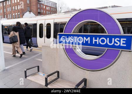 I passeggeri scendono dalla Elizabeth line alla stazione della metropolitana di Custom House con il logo della rotonda TFL su Planform, Londra, Inghilterra Foto Stock