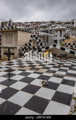 Famoso cimitero, molti mausolei o grandi tombe decorate con piastrelle, spesso in bianco e nero. Edifici densamente costruiti sotto una spettacolare copertura nuvolosa Foto Stock