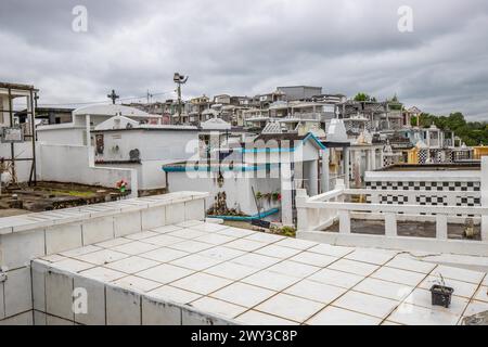 Famoso cimitero, molti mausolei o grandi tombe decorate con piastrelle, spesso in bianco e nero. Edifici densamente costruiti sotto una spettacolare copertura nuvolosa Foto Stock