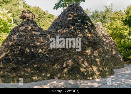 Tre grandi capsule del tempo in pietra e rocce impilate a forma di coni nel parco pubblico della Corea del Sud Foto Stock