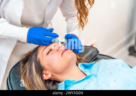 Cosmetologo che fa l'iniezione di botox al viso di una donna adulta caucasica in una clinica Foto Stock