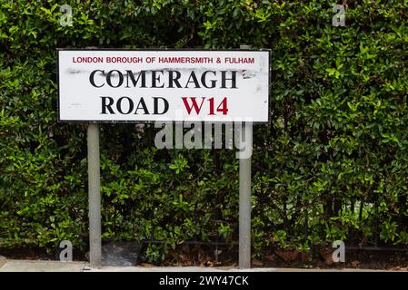 Cartello stradale Comeragh Road, in West Kensington, W14, London Borough of Hammersmith & Fulham. Cartello stradale contro il Bush verde Foto Stock