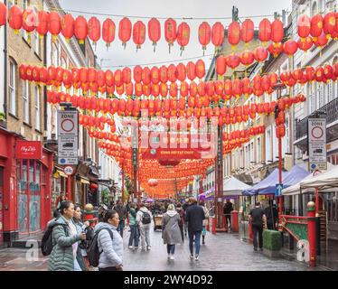 Wardour Street a Chinatown, Londra, brulicante di folle di acquirenti e turisti. Persone che camminano sotto le lanterne cinesi nella Chinatown di Londra. Foto Stock