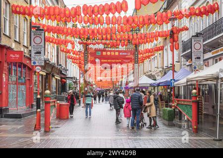 Wardour Street a Chinatown, Londra, brulicante di folle di acquirenti e turisti. Persone che camminano sotto le lanterne cinesi nella Chinatown di Londra. Foto Stock