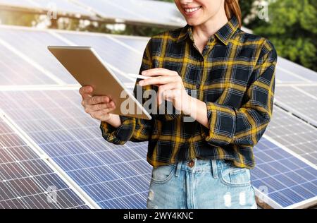 Ingegnere donna controlla le condizioni tecniche dei pannelli solari utilizzando un tablet digitale. Foto Stock